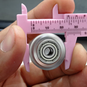Solid V Wheel For 4040 Aluminum Profile Transparent - shown in a close-up view being measured by a pink plastic caliper.