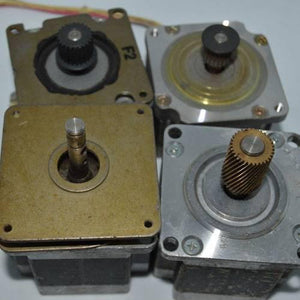 Stock Lot Used Bipolar NEMA 23 Stepper Motor Lot - four square metallic stepper motors with various gear attachments on their shafts.