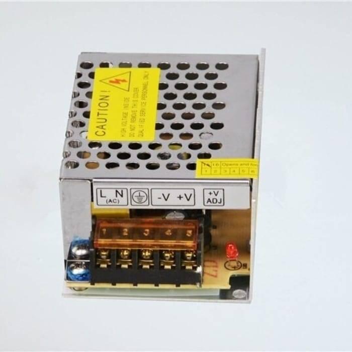 Switching Power Supply SMPS 12V 5A - a silver metal casing with a yellow caution label, a terminal block for AC/DC connections, and a red LED.