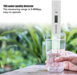 TDS Meter Digital Water Quality Tester - a white handheld device with a digital display showing 83, held in a glass of water against a blurred background.
