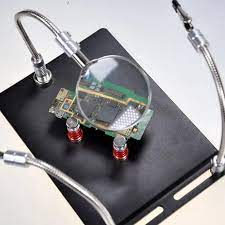 TE-804 Soldering Third Hand Magnetic Universal PCB Motherboard Fixture With Magnifier - a black metal base, flexible arms, and a magnifying glass over a PCB.