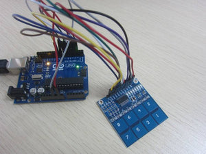 TTP226 8 Channel Digital Capacitive Touch Sensor Module - connected to an Arduino Uno board with multi-coloured jumper wires on a wooden surface.