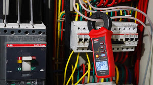 UNI-T UT251C+ AC Leakage Current Clamp Meter – 1µA Resolution, 3mA to 60A, 40mm Jaw, Harmonic Test, LPF, Bluetooth, Dual Display, CAT III 600V - clamped onto electrical wires, showing 50.02 and 29.71 on its digital display.
