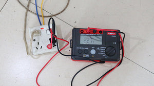 UNI-T UT502A Insulation Resistance Tester – Digital Megohmmeter, 500V/1000V/2500V - connected to a wall socket with red and black leads, showing a 227V reading on its digital display.