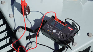 UNI-T UT502A Insulation Resistance Tester – Digital Megohmmeter, 500V/1000V/2500V - with red and black leads to a surface, showing a digital display reading 1.09 and 26.17.