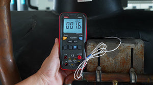 UNI-T UT60S True RMS Digital Multimeter – 9999 Count, AC/DC 1000V, 10A, Capacitance, Frequency, Temperature, NCV, 3-Color LED Alert, CAT III 600V - held in a hand, showing a black and red body with buttons, a digital display reading 0016, and a connected temperature probe.