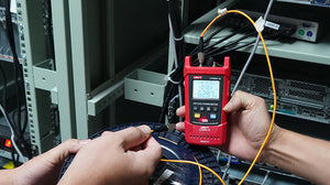 UNI-T UT695D-10 Optical Multimeter – Fiber Power Meter (-70~3dBm, 800–1700nm) + 10mW VFL + LAN Cable Test + Flashlight, FC/SC/ST, Rechargeable - a red handheld device with a digital display reading -62.97, held while testing an orange fiber optic cable.