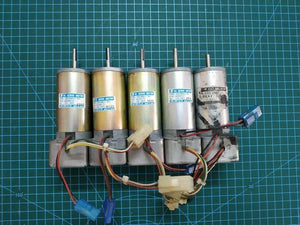 Used DC Servo Motor With Encoder High Speed 24V DC DSE38BE27-001IN Pakistan - five cylindrical metal motors with attached wires and connectors on a green grid.