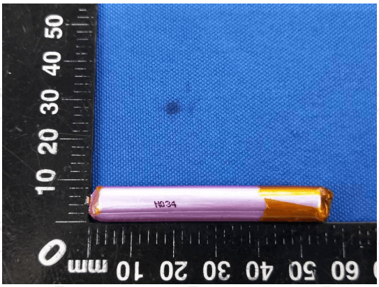 Used High Quality 3.7V 280mAh Battery - a thin, cylindrical, pink and gold-taped battery placed against a millimeter ruler for scale.