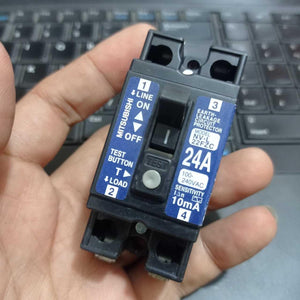 Used Mitsubishi NV-L22FZC 24A Earth Leakage Circuit Breaker Switch - a black rectangular electrical switch held in a hand, featuring a test button and ON/OFF toggle.