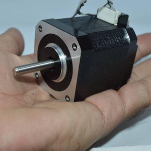 Used NEMA 17 4.2 Kg-cm Stepper Motor For CNC And 3d Printer - a black and silver square motor with a protruding metal shaft and a white connector port held in a hand.