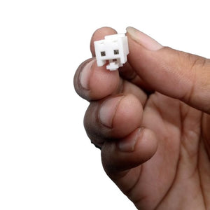Used Power Supply Adapter 24V 5A 120W - close-up of a small white plastic two-pin electrical connector held between fingers.