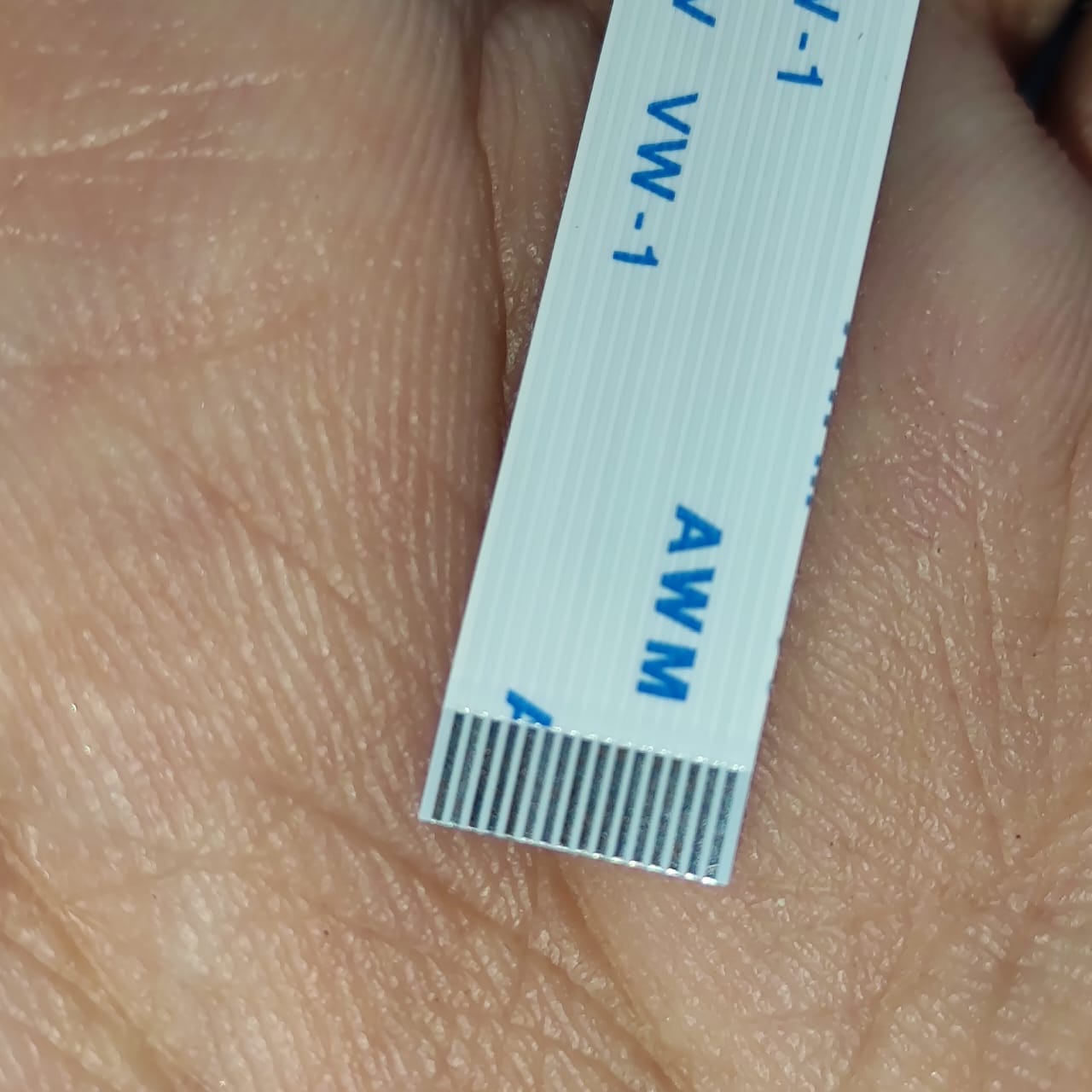 0.5-16P-120mm 0.5 Inch Pitch 16 Pin 120mm Leght Ffc Flexible Flat Cable - a close-up showing the white ribbon cable and its metallic connector pins.