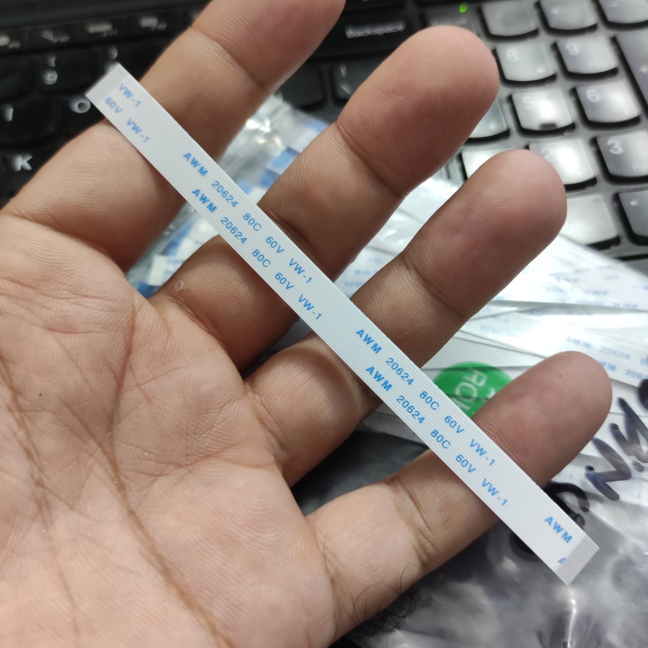 0.5-16P-120mm 0.5 Inch Pitch 16 Pin 120mm Leght Ffc Flexible Flat Cable - a long, thin, white ribbon cable with 16 pins, held in a hand with printed AWM 20624 80C 60V VW-1 markings.