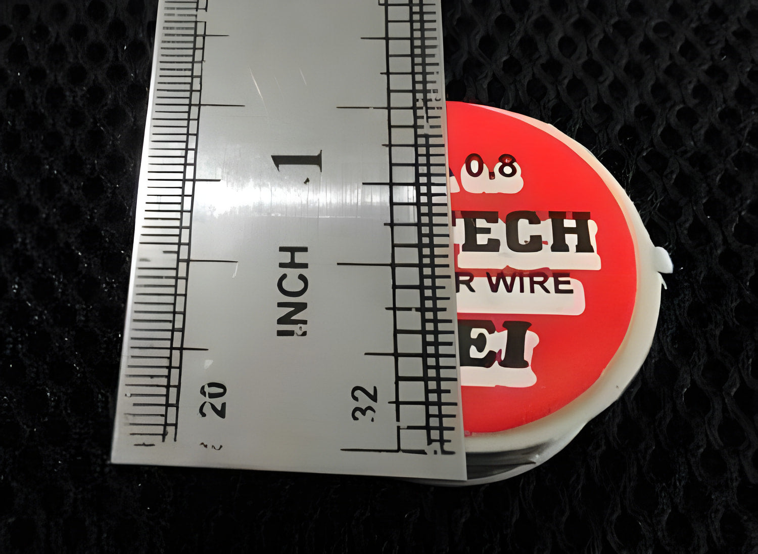 0.8mm 2.5ft Soldering Wire - shown in a close-up top-down view next to a metal ruler measuring its diameter.