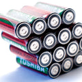 1.5V Non Rechargeable Cell AA Cell Camera Cell AA Clock Cell - stack of red and green Toshiba AA batteries arranged in a pyramid formation on a white background.