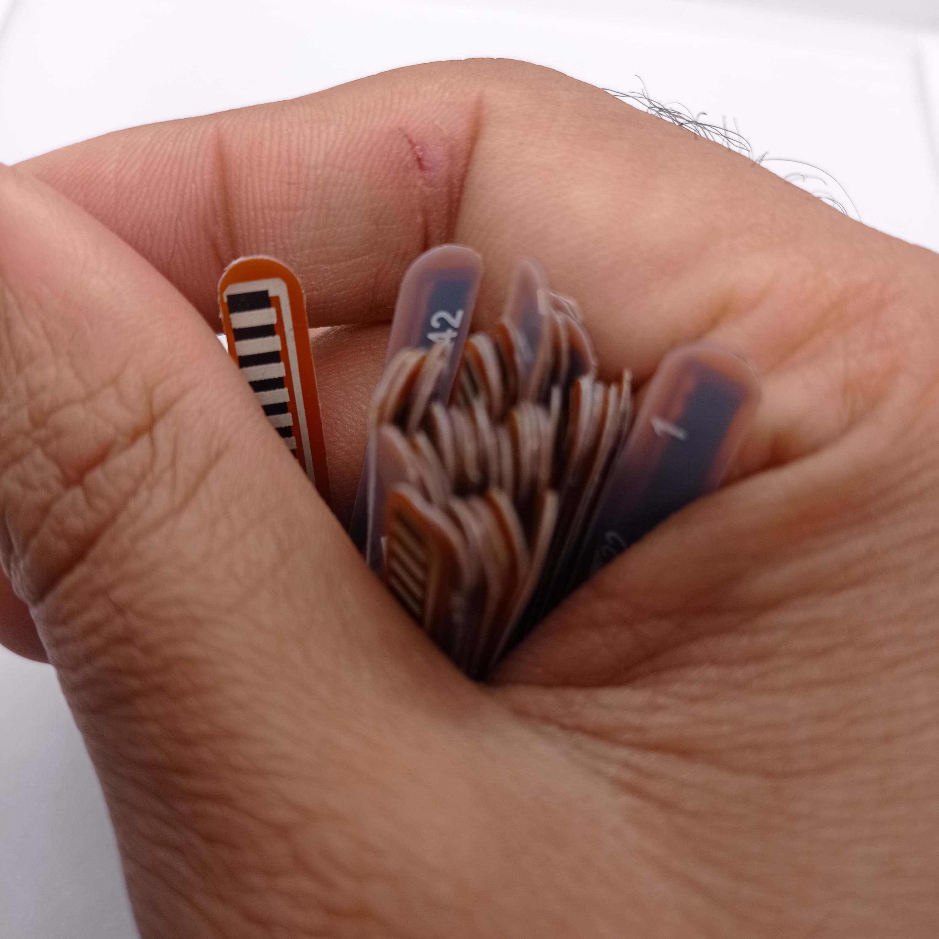 1 Piece 2.2 Inch Flex Sensor Bend Detection Sensor - a close-up of multiple thin, brown, rectangular sensor strips with visible numbering.