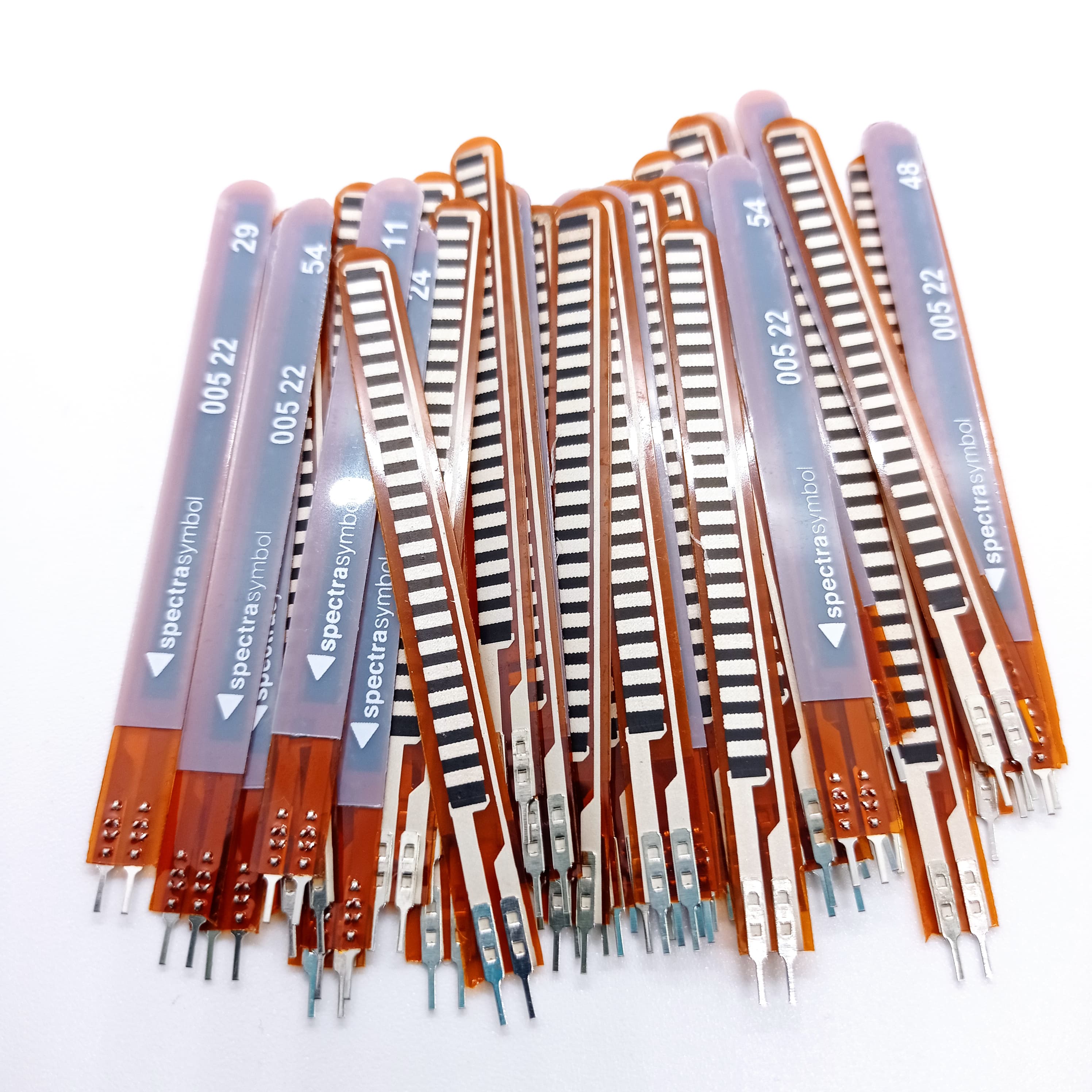 1 Piece 2.2 Inch Flex Sensor Bend Detection Sensor - a pile of thin, orange, flexible strips with black sensor patterns and two-pin connectors at the base.