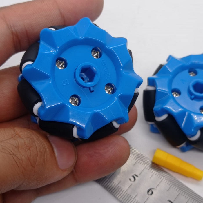 1 Piece 52mm Mecanum Omni Wheels Tires For DIY Rc Robot Toys Tt Motors - two blue wheels with black rollers held by a hand next to a metal ruler and a yellow hexagonal axle connector.