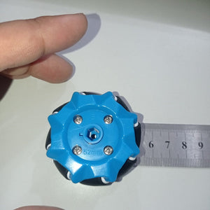 1 Piece 52mm Mecanum Omni Wheels Tires For DIY Rc Robot Toys Tt Motors - a blue plastic wheel with black rollers being measured by a metal ruler.