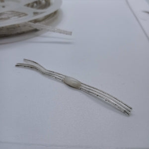 1 Piece RGB Waterproof WS2812 Addressable LED Strip For Arduino (individually Controllable!) - a close-up of a single LED component on a thin, transparent wire strip with a spool in the background.
