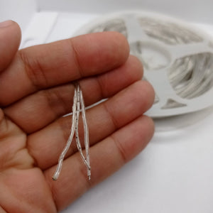 1 Piece RGB Waterproof WS2812 Addressable LED Strip For Arduino (individually Controllable!) - close-up of a hand holding the stripped wire ends of a coiled, transparent LED strip.