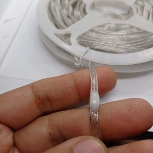 1 Piece RGB Waterproof WS2812 Addressable LED Strip For Arduino (individually Controllable!) - shown as a close-up of the wire held in a hand with the strip coiled on a plastic spool.