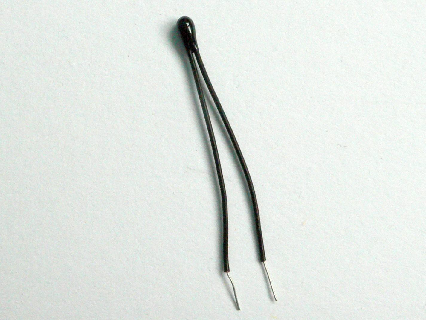100k Precision NTC Thermistor - shown as a small, black, bead-shaped electronic component with two thin, insulated wire leads extending from the top.
