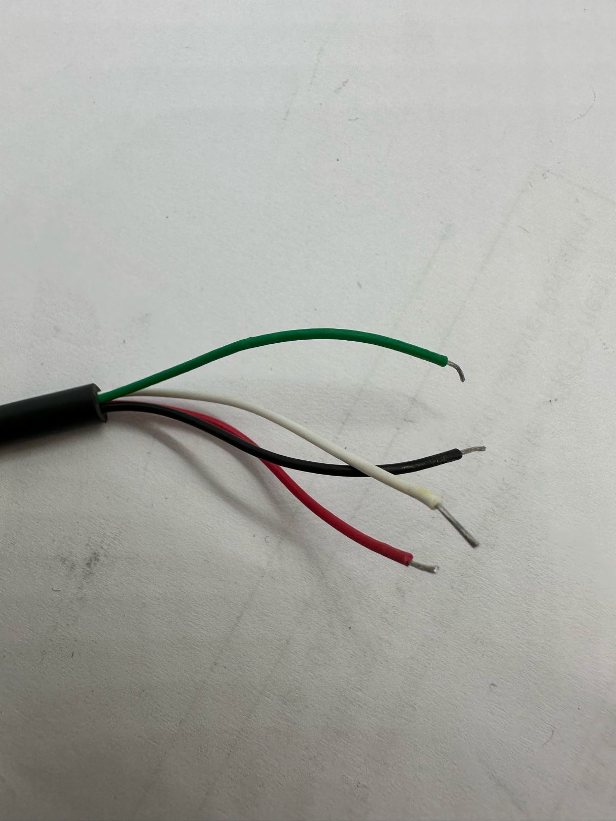 100kg Capacity Load Cell - close-up view of the four exposed, stripped wire ends in green, white, black, and red insulation.