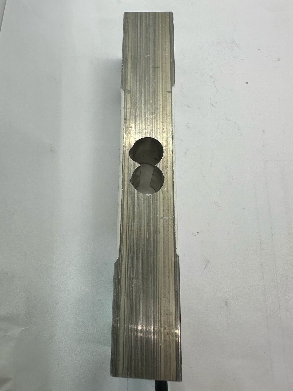 100kg Capacity Load Cell - a top-down view of the rectangular silver metal sensor bar with a central figure-eight shaped cutout.