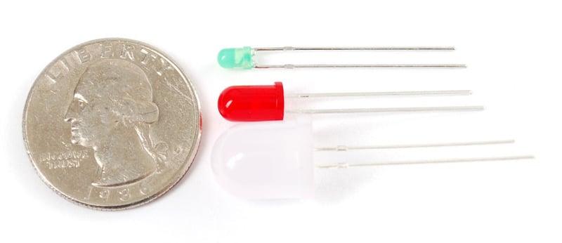 10mm Green LED Light Emitting Diode - shown next to a red LED, a larger clear LED, and a US quarter coin for size comparison.