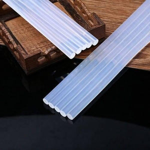 11mm Hot Melt Glue Sticks Electric Heating Adhesive Film Craft Glue Stick - a cluster of translucent, cylindrical adhesive sticks arranged on a dark surface and a wooden tray.