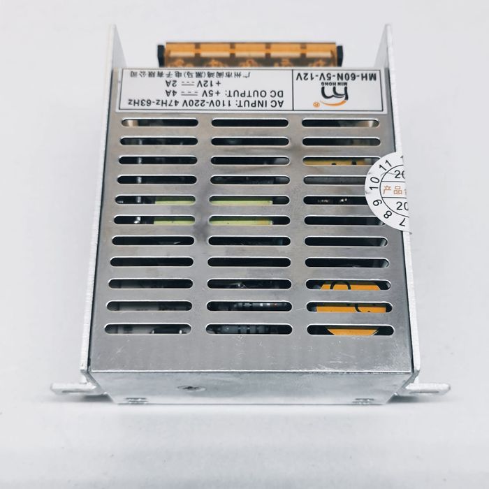 12V 2A And 5V 4A Dual Output DC Power Supply - shown as a silver metal-cased unit with a top-mounted terminal block and a product specification label.