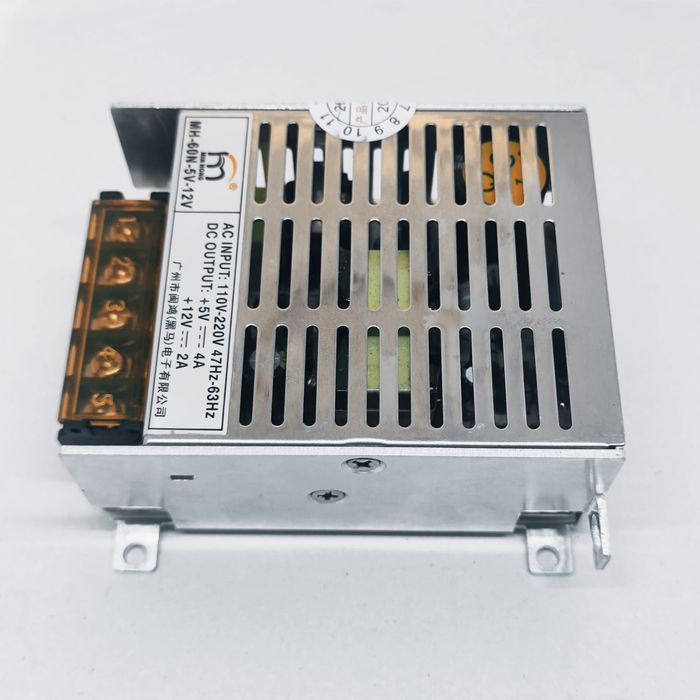 12V 2A And 5V 4A Dual Output DC Power Supply - a silver metal-cased unit with a five-terminal screw block and a printed label showing input/output specs.