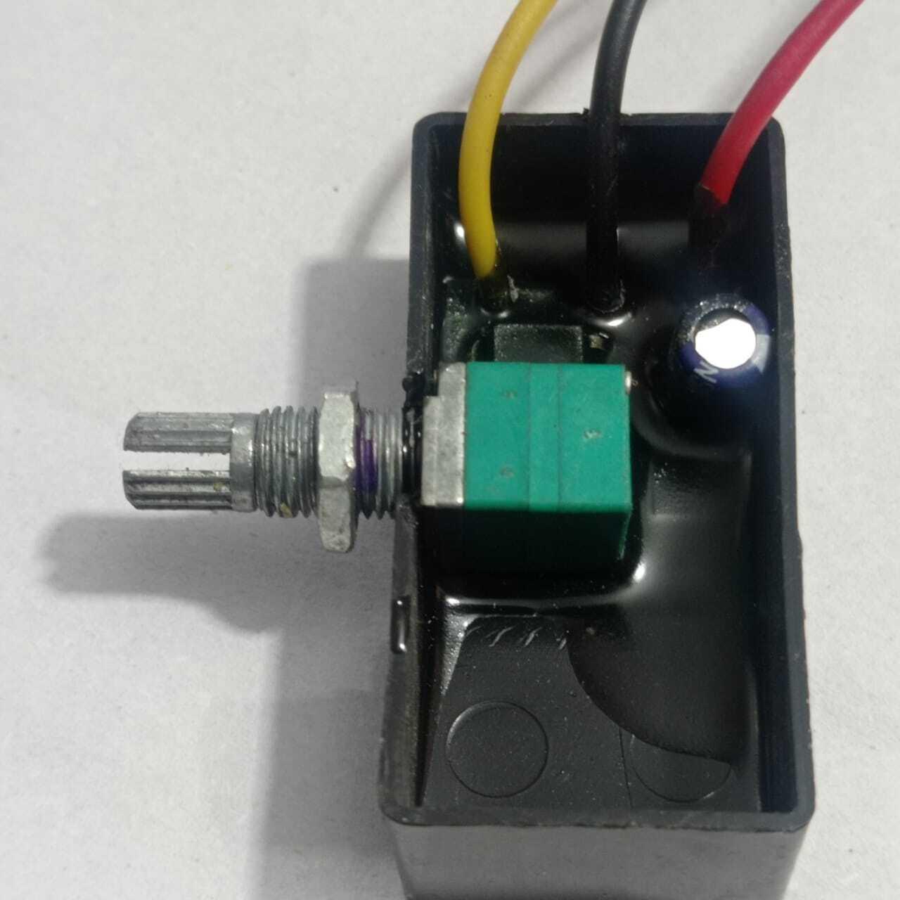 12V 5A DC Dimmer PWM - shown as an internal view of a black plastic housing containing a green potentiometer with a metal shaft and a small capacitor.
