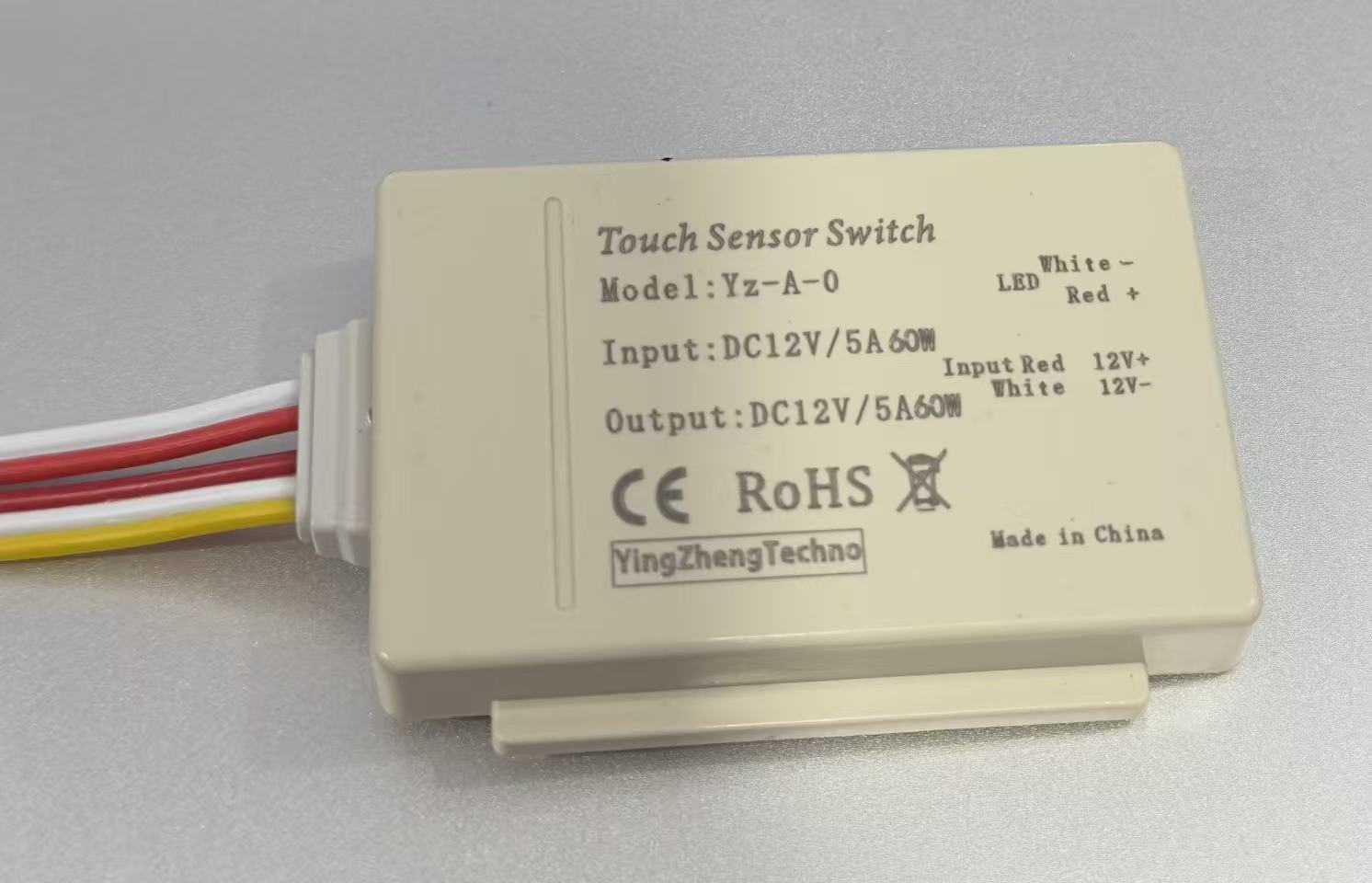 12V 60W (5A) Mirror Touch Sensor - shown as a rectangular beige device with a label detailing specifications and four colored wires extending from one side.