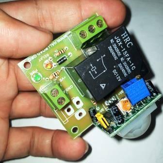 12V PIR Motion Sensor Switch Module - a black relay, green terminal blocks, a blue potentiometer, and a white dome sensor.