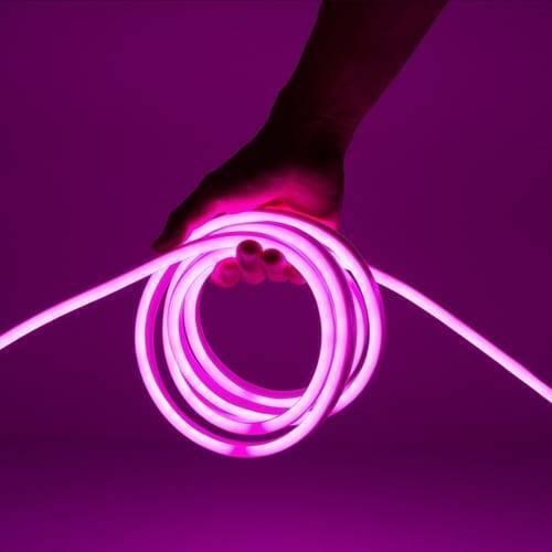 12V Purple Neon Flexible Strip Light 1m Waterproof SMD 5050 Rope String Silicone Lamp Outdoor Lighting - shown as a glowing purple coil of silicone rope being held by a hand against a matching purple background.