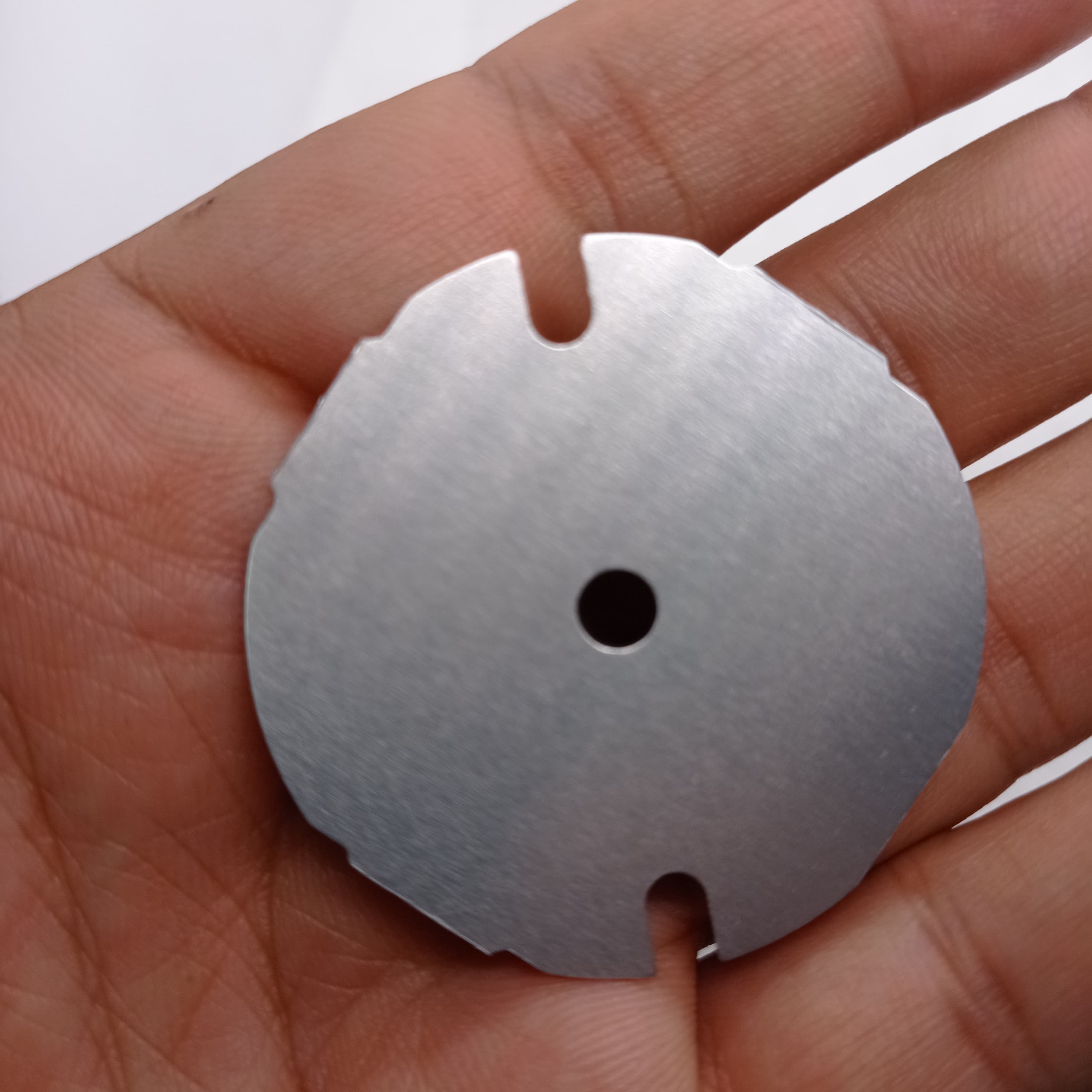 12W 220V LED Light - a circular silver-coloured metal LED base plate with a central hole and two semi-circular edge cutouts held in a hand.