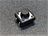 12x12x7.5mm Tactile Push Button Switch - a black square tactile switch with a round center button and four metal pins, shown in a close-up view.