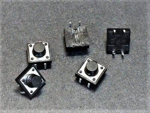 12x12x9mm Tactile Push Button Switch - shown as a collection of five black square tactile switches with round push buttons on a dark grey surface.