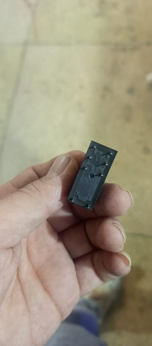 16A 250VAC 24V 8 Pin Relay - a close-up showing the black rectangular base of the component with eight metal connector pins held in a hand.