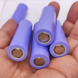 18650 Lithium Ion Cell refurb - a hand holding five cylindrical purple battery cells with visible flat metal contact points.