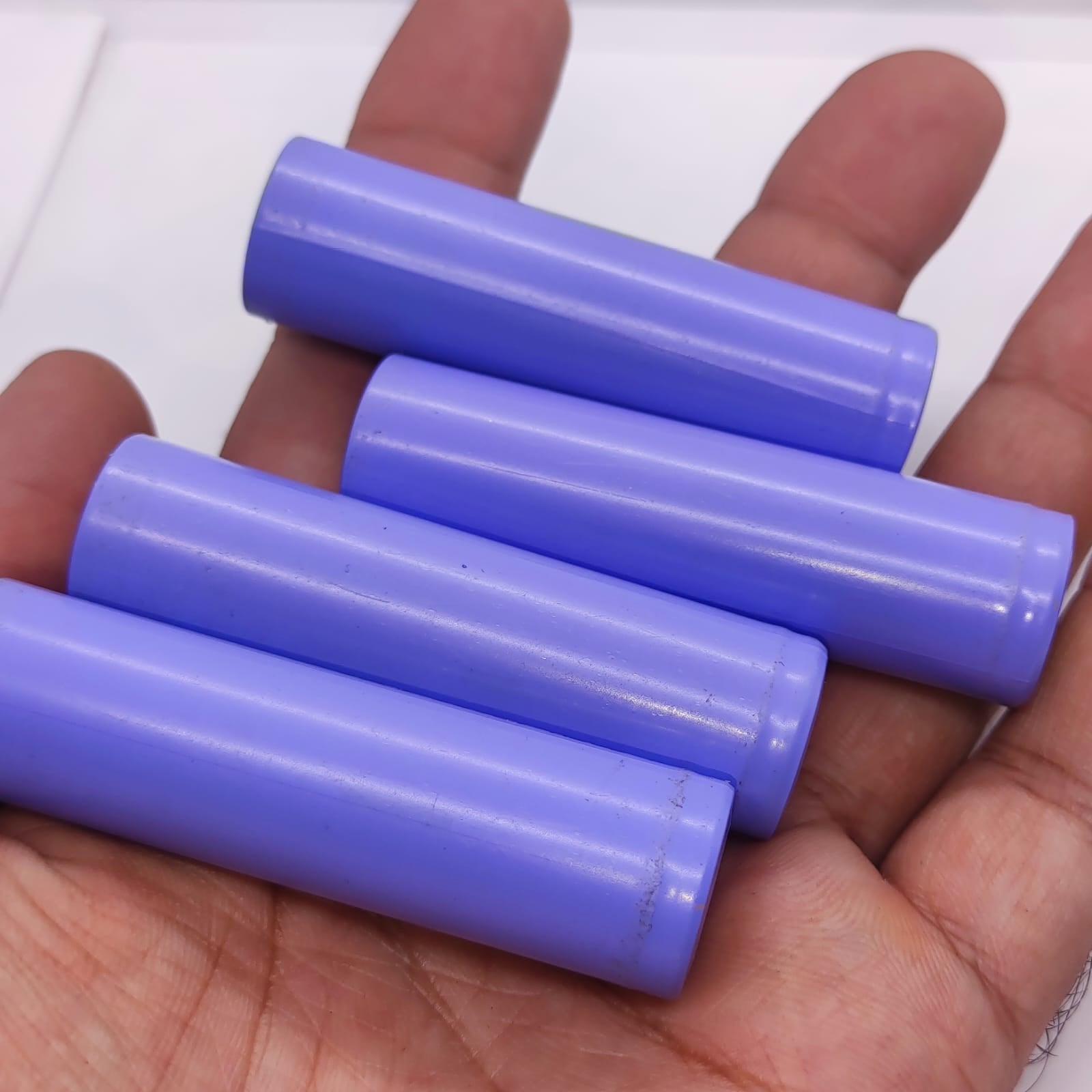 18650 Lithium Ion Cell refurb - four light purple cylindrical battery cells held in a person's palm.