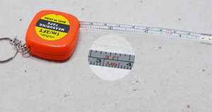 1m/ 3ft Pocket Size Inchies Tape And Measuring Tool - shown as an orange square case with a keychain and an extended tape measure with a magnified view.