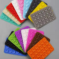 1pcs Silicone Suction Mobile Holder Pad - shown in a variety of rectangular, multi-coloured silicone mats featuring rows of small suction cups.