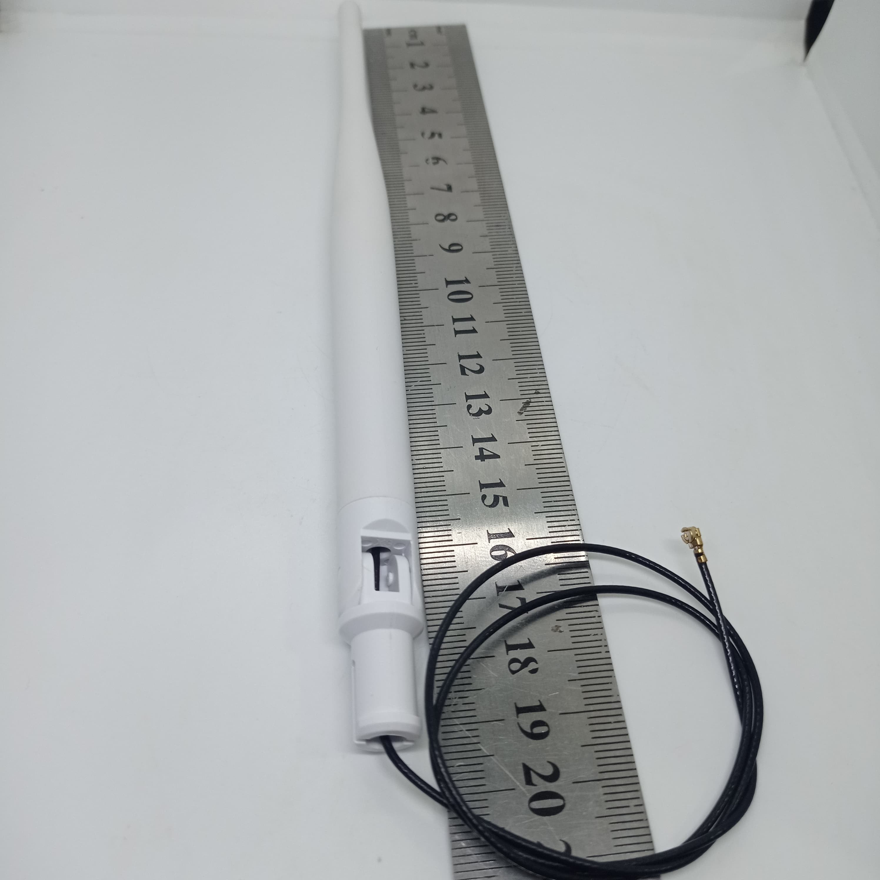 2.4GHz-5.8GHz 5db Wi-Fi Antenna With Ipex Connector - shown with a black cable and connector next to a metal ruler for scale.