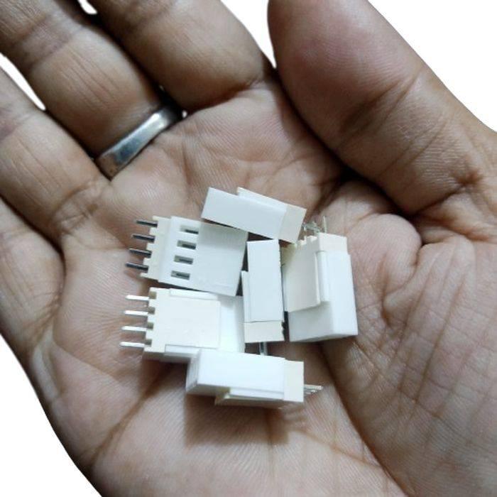 2.54mm 4-pin Male Female Connector - a close-up shot of several white plastic 4-pin electronic connectors held in a human hand.