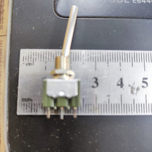2 Position Long Toggle Switch Frsky Taranis - shown from the side with a metal lever, a green base with three pins, and a ruler for scale.