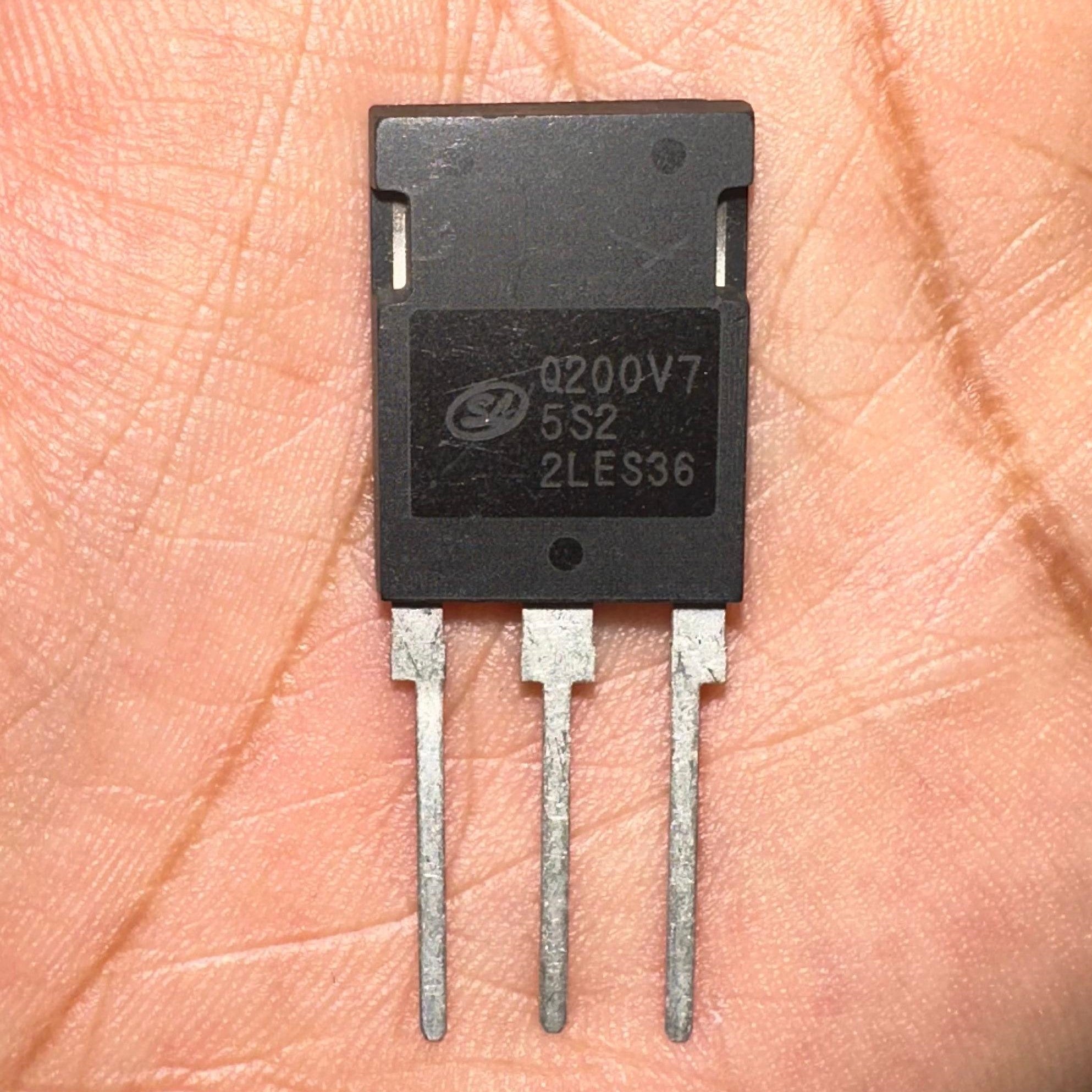 200A 750V IGBT Q200V75SDB1 SGTQ200V75SDB1-digilog.PK - a black three-pin electronic component held in a palm with the text Q200V7, 5S2, and 2LES36 printed on its face.